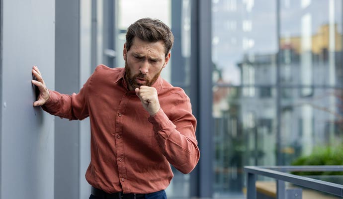Person coughing at outdoor due to health issues Person coughing at outdoor due to health issues