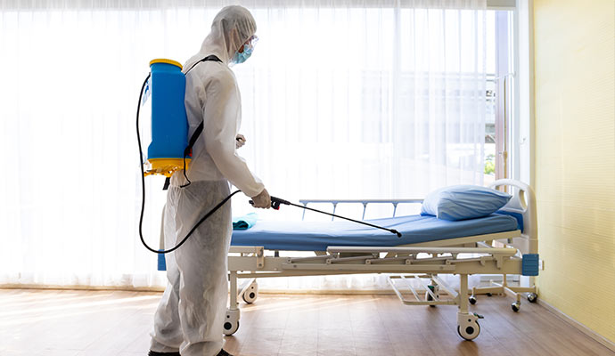 Professional disinfecting hospital room with backpack sprayer