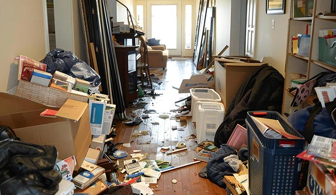 Cluttered hallway with hoarded items and scattered belongings Cluttered hallway with hoarded items and scattered belongings