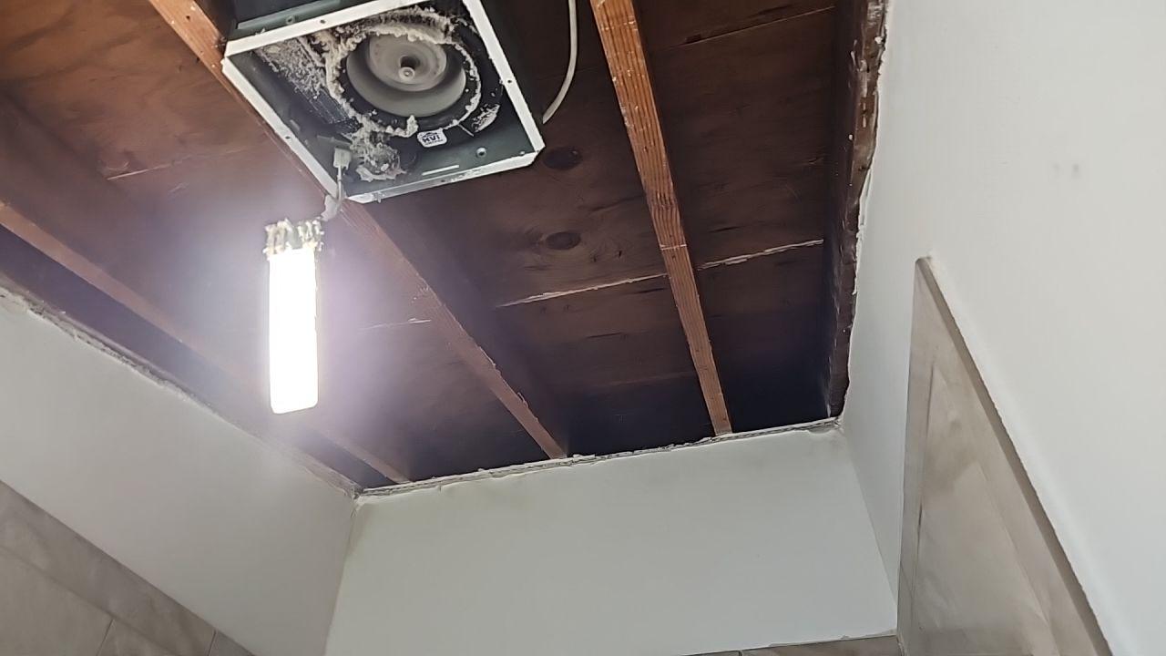 A bathroom ceiling is opened up to address water damage and ensure proper drying of the structure. This necessary demolition is part of our comprehensive water damage restoration process, allowing us to access and repair hidden damage from a leak.