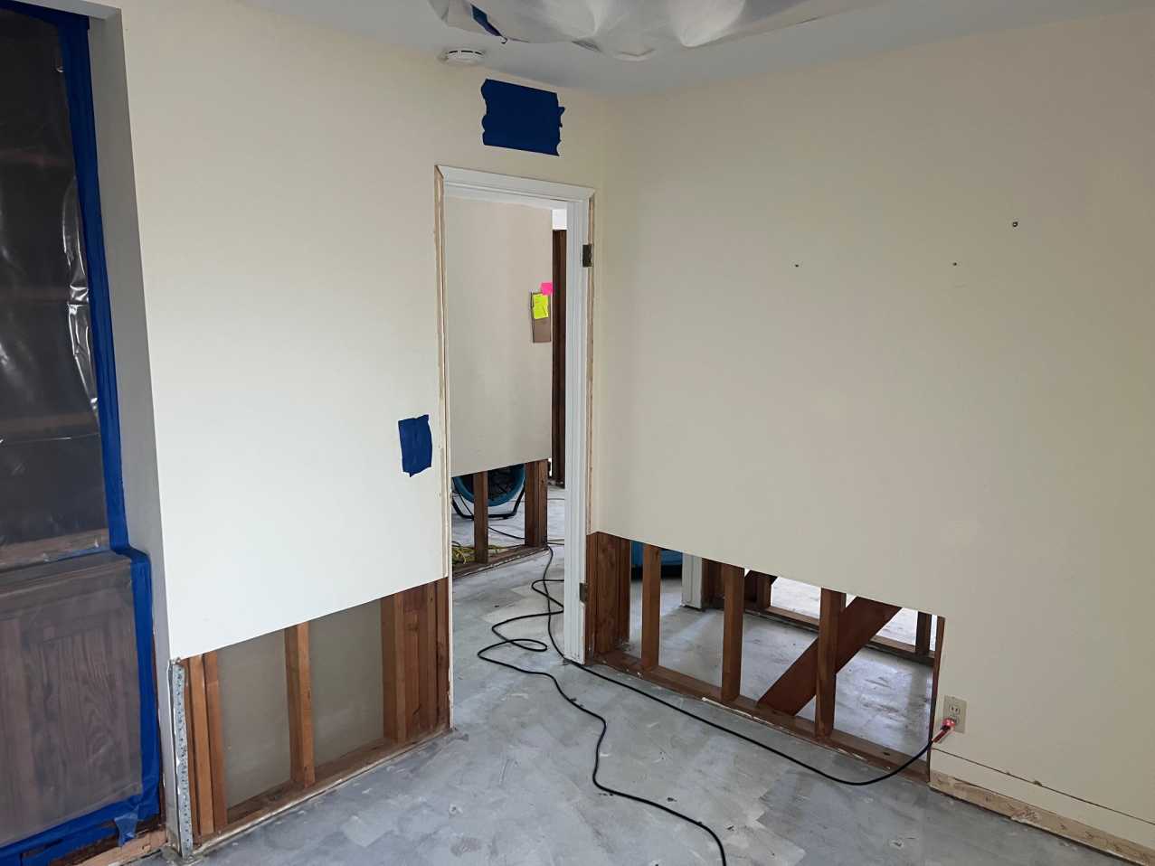 Reconstruction in progress showing sections of drywall removed to the studs for structural repair and access, illustrating the preparation required before final property restoration and finish work.