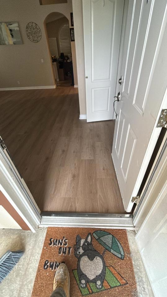View of the entryway showing the seamless flooring restoration following water mitigation services, confirming the property is fully dry and complete after water damage repair.