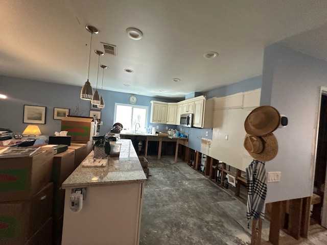 Initial assessment of kitchen water damage and demolition after a refrigerator leak. Showing removed cabinets and flooring for water mitigation and structural drying.
