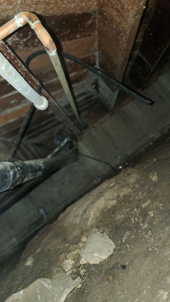Crawl space inspection showing plumbing pipes and potential leak source, confirming the need for immediate emergency water mitigation and structural drying services to address the water damage.
