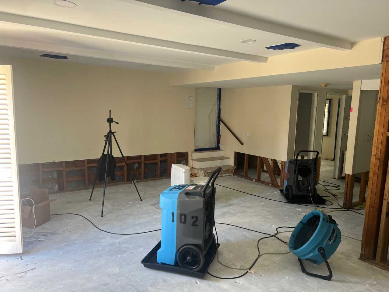 Reconstruction preparation in an office space, showing removed drywall and vinyl plank flooring, with drying equipment for final structural drying before rebuild services and property restoration.