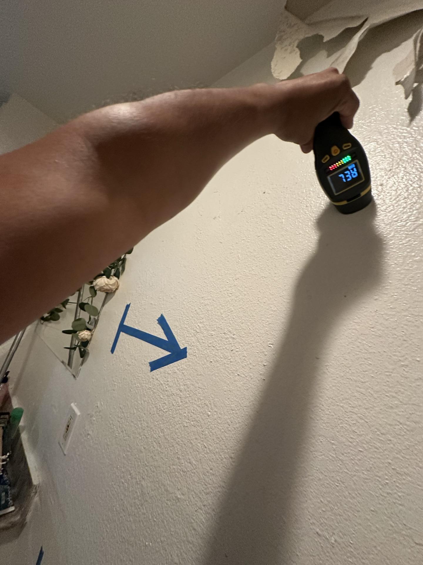 A technician using a moisture meter (reading 73.8) to detect high moisture levels in a bathroom wall, a key indicator of mold growth. This initial assessment is vital for our professional mold remediation process, helping to precisely define the containment area and ensure effective mold removal and moisture control.