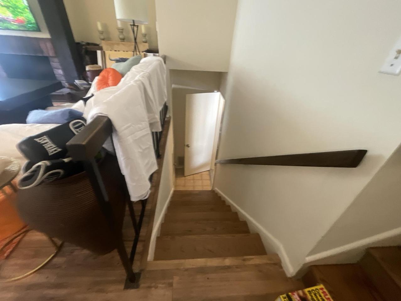 A view down a residential staircase and handrail requiring professional fire damage restoration. Our deep cleaning service ensures all surfaces and high-touch areas are thoroughly cleaned and treated for smoke and soot removal and effective odor control.