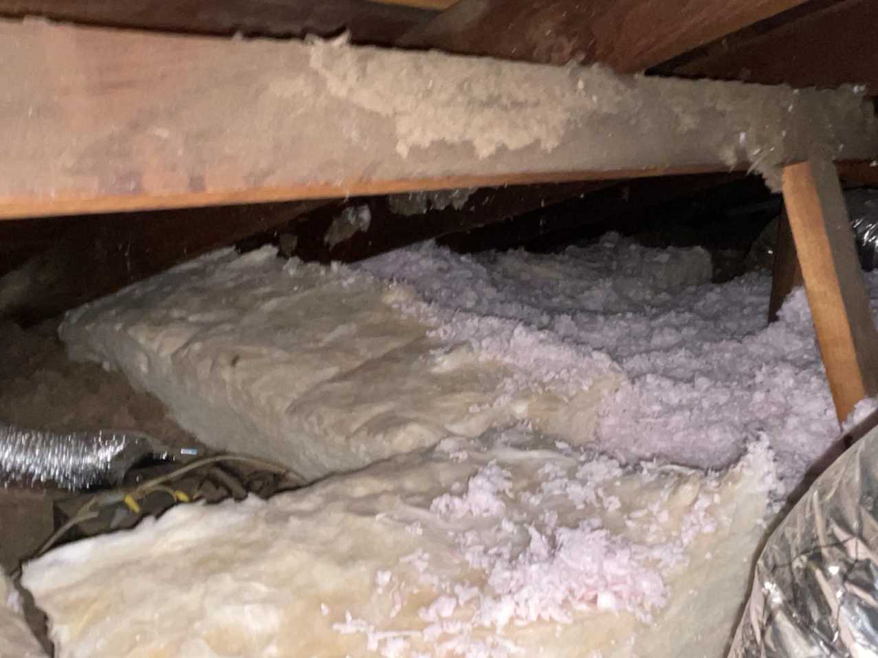 Attic insulation showing smoke damage and contamination, which can trap odors and require specialized smoke mitigation. As part of our comprehensive fire damage restoration, we assess and treat the attic to ensure complete odor elimination from the entire structure.