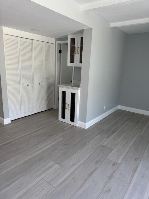 Final property reconstruction of a living area, showcasing newly installed vinyl plank flooring, custom cabinets, and fresh paint, achieving a full structural repair and restoration to pre-loss condition.