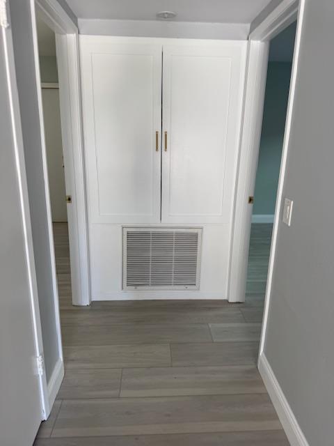 Completed property reconstruction in a hallway, showcasing the final installation of new vinyl plank flooring, fresh paint, and restored trim, returning the area to pre-loss condition.