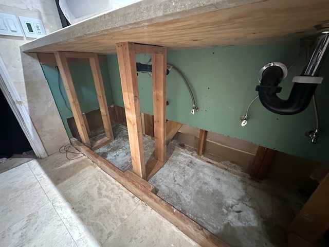 Temporary wooden supports are installed to shore up a countertop after a slab leak. This crucial step allows our team to safely remove the damaged vanity and access the plumbing and subfloor for slab leak repair and complete water damage restoration