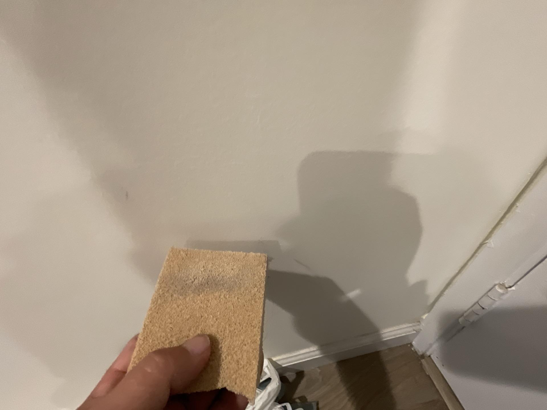 Close-up showing a test sponge revealing soot damage and smoke residue on a hallway wall, essential for planning thorough fire damage cleanup and effective smoke odor removal for the property.